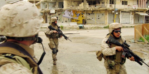 U.S. Marines from the 3rd Battalion, 8th Marine Regiment's Kilo Company run across a war-battered road to avoid snipers on their way back to a base at the headquarters of the provincial government of Anbar province during a patrol in Ramadi, Iraq on Monday, April 17, 2006. Reining in Ramadi, through arms or persuasion, could be the toughest challenge for Prime Minister Nouri al-Maliki's new government. Al-Maliki has promised to use "maximum force" when needed. But three years of U.S. military presence, with nearly constant patrols and sweeps, hasn't done it. (AP Photo/Todd Pitman)
