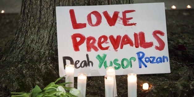 CHAPEL HILL, USA - FEBRUARY 11: A sign is seen a vigil at the University of North Carolina for Deah Shaddy Barakat, his wife Yusor Mohammad, and her sister Razan Mohammad Abu-Salha who were killed in their home the night before in Chapel Hill, North Carolina, USA, on February 11, 2015. A 46-year-old man was charged with the murder of three Muslim students who were fatally shot Tuesday at the University of North Carolinas residential complex in Chapel Hill, police said Wednesday. (Photo by Samuel Corum/Anadolu Agency/Getty Images)