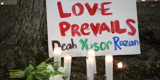 CHAPEL HILL, USA - FEBRUARY 11: A sign is seen a vigil at the University of North Carolina for Deah Shaddy Barakat, his wife Yusor Mohammad, and her sister Razan Mohammad Abu-Salha who were killed in their home the night before in Chapel Hill, North Carolina, USA, on February 11, 2015. A 46-year-old man was charged with the murder of three Muslim students who were fatally shot Tuesday at the University of North Carolinas residential complex in Chapel Hill, police said Wednesday. (Photo by Samuel Corum/Anadolu Agency/Getty Images)