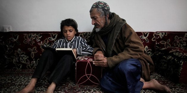 SANA'A, YEMEN - JANUARY 20: Nine-year-old Yemeni Jew Salim Moussa reads the Torah with Yusuf Moussa Salim inside a protected