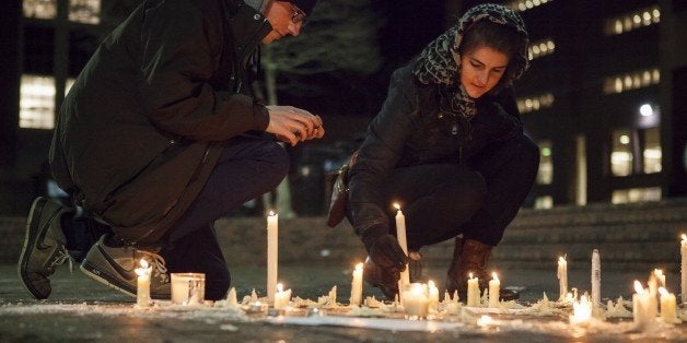 CHAPEL HILL, USA - FEBRUARY 11: Lee Elliott (L) from Chapel Hill, N.C. and Tera Schmitt (R) from Durham, N.C. relight candles in a memorial at a vigil at the University of North Carolina for Deah Shaddy Barakat, his wife Yusor Mohammad, and her sister Razan Mohammad Abu-Salha who were killed in their home the night before in Chapel Hill, North Carolina, USA, on February 11, 2015. A 46-year-old man was charged with the murder of three Muslim students who were fatally shot Tuesday at the University of North Carolinas residential complex in Chapel Hill, police said Wednesday. (Photo by Samuel Corum/Anadolu Agency/Getty Images)