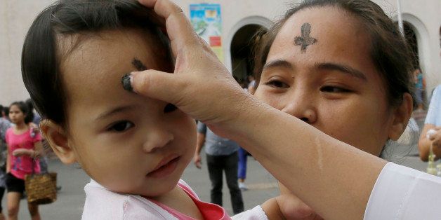 A Catholic nun uses ash to mark a cross on the forehead of a child in observance of Ash Wednesday at The Redemptorist Church at suburban Paranaque city south of Manila, Philippines Wednesday, Feb. 18, 2015. Ash Wednesday marks the start of the Lent, a season of prayer and fasting before Easter. (AP Photo/Bullit Marquez)