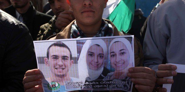 GAZA CITY, GAZA - FEBRUARY 12: A group of Palestinians protest against the Chapel Hill shooting, in front of the United Nations office in Gaza City, Gaza on February 12, 2015. Three young Muslim Students, Deah Shaddy Barakat, his wife Yusor Mohammad, and her sister Razan Mohammad Abu-Salha were killed on 10th of February 2015 in Chapel Hill, North Carolina, United States at their home on 10th of February 2015. A 46-year-old man was charged with the murder of three Muslim students who were fatally shot Tuesday at the University of North Carolinas residential complex in Chapel Hill, police said Wednesday. (Photo by Ashraf Amra/Anadolu Agency/Getty Images)