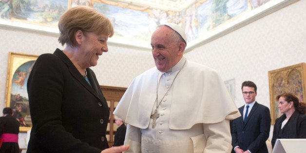 VATICAN CITY, VATICAN - FEBRUARY 21: Pope Francis exchanges gifts with Chancellor of Germany Angela Merkel during a private audience at the Apostolic Palace on February 21, 2015 in Vatican City, Vatican. This is a second time that German Chancellor Angela Merkel been granted a private audience with the Pope, where global poverty and climate change are expected to be discussed. (Photo by Vatican Pool/Getty Images)