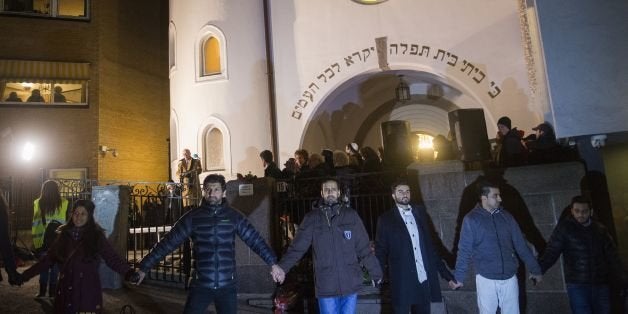 Norwegian Muslims create a human peace ring around the synagogue in Oslo, Norway on February 21, 2015. More than a 1,000 joined a peace vigil in Oslo Saturday, hosted by young Norwegian Muslims in a show of solidarity with Jews a week after fatal shootings in Denmark targeted a synagogue and free speech seminar. AFP PHOTO / FREDRIK VARFJELL (Photo credit should read Fredrik Varfjell/AFP/Getty Images)