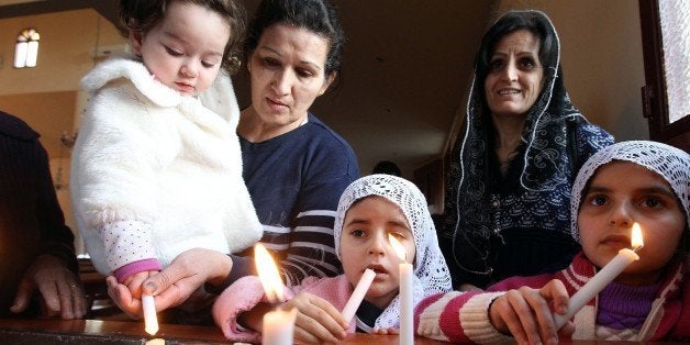 Assyrian Christian women and their daughters, who had fled the unrest in Syria, attend a prayer for the 220 Assyrian Christians abducted by Islamic State group jihadists from villages in northeastern Syria in recent days, at the Saint Georges Assyrian Church in Jdeideh, northeast of the Lebanese capital Beirut on February 26, 2015. AFP PHOTO / ANWAR AMRO (Photo credit should read ANWAR AMRO/AFP/Getty Images)