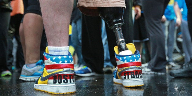 BOSTON - APRIL 15: Boston Marathon bombing victim J.P. Norden wore colorful sneakers with 'Boston Strong' written on the back. Brothers J.P. Norden and Paul Norden crossed the Marathon finish line on Boylston Street along with a large group of family and friends after they had taken turns walking the entire Marathon course all day, April 15, 2014, the one year anniversary of the tragedy. (Photo by Jim Davis/The Boston Globe via Getty Images)