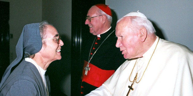 Pope John Paul II is greeted by Sister Enrica Rosanna, of the Salesian order, in this 2002 photo made available by the Vatican, Saturday, April 24, 2004. Sister Rosanna, 65, has been named by the pope undersecretary of the Congregation for Institutes of Consecrated Life and Societies of Apostolic Life, the highest position ever held by a woman in the Roman Catholic Church. At center is Belgian Cardinal Jan Pieter Schotte. (AP Photo/Osservatore Romano)