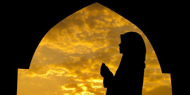Silhouette of Female Muslim praying in mosque during sunset time
