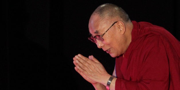 Tibetan spiritual leader the Dalai Lama greets the audience as he arrives to speak on "A Human Approach to World Peace" at Presidency College in Kolkata, India, Tuesday, Jan. 13, 2015. (AP Photo/Bikas Das)