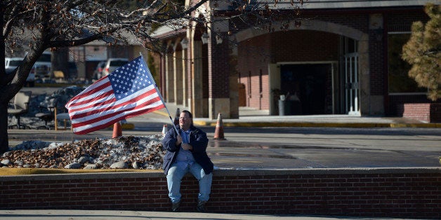 LAKEWOOD, CO - JANUARY 14: A New Hope Ministries, Center of Hope program participant waves an American Flag, trying to lure drivers on S. Sheridan Blvd to the church's car wash in the parking lot January 14, 2015. The Pastor of New Hope Ministries, Ray Chavez, stopped a funeral service Saturday at the church for Vanessa Collier when pictures of her and her wife were displayed. (Photo by Andy Cross/The Denver Post via Getty Images)