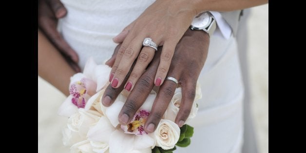 Bride and groom put their hands together and show the rings