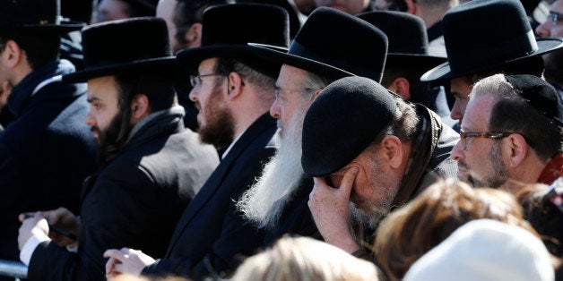 Mourners gather during funeral services for the seven siblings killed in a house fire, Sunday, March 22, 2015, in the Brooklyn borough of New York. The siblings, ages 5 to 16, died early Saturday when flames engulfed the Sassoon family home in the Midwood neighborhood of Brooklyn. Investigators believe a hot plate left on a kitchen counter set off the fire that trapped the children and badly injured their mother and another sibling. (AP Photo/Julio Cortez)