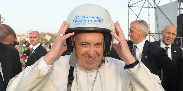 In this March 21, 2015 pool photo, made available Monday, March 23, 2015, Pope Francis wears a helmet as he meets youths in Naples, Italy. Pope Francis made an impassioned defense of the unemployed during a speech to people in the poor Neapolitan neighborhood of Scampia Saturday. (AP Photo/L'Osservatore Romano, Pool)