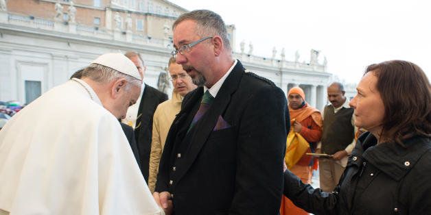 Pope Francis greets Michael Haines as Barbara Henning, right, stands behind him, during the pontiff weekly general audience in St. Peter's Square, at the Vatican, Wednesday, March 25, 2015. Relatives of two British hostages killed by the Islamic State group have met with Pope Francis as part of efforts to unite people of different faiths to oppose religious extremism. Michael Haines, whose brother David was killed in September, 2014, and Barbara Henning, whose husband Alan was killed the following month, were brought up to greet Francis on the steps of St. Peter's Basilica after his rain-soaked general audience Wednesday. (AP Photo/L'Osservatore Romano, Pool)