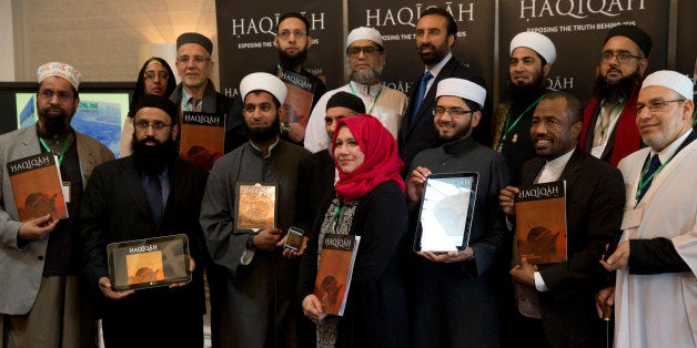 Leading Imams and scholars from Britain and Europe, from the third left, Imam Asim Hussain, Sarah Warrick, Dr Qari Muhammad Asim and Shaykh Ahmad Babikir hold up various versions, online and printed of the new magazine 'Haqiqah' which translates as 'The Reality' and is aimed young people and to counter extremist views from groups such as Islamic State, at its official launch in London, Thursday, March, 26, 2015. (AP Photo/Alastair Grant)