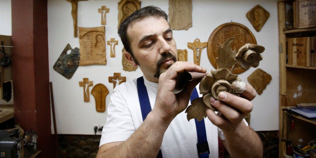 In this photo taken on Saturday, March, 28,2015 Bosnian Muslim craftsman Edin Hajdarovac engraves decoration onto part a wooden chair in his workshop in Bosnian town of Zavidovici, 170 kms north of Sarajevo. Salem Hajdarovac didn't sleep for a whole week when he heard his workshop had been granted the honor of carving a special chair that Pope Francis will sit on during his visit to Bosnia. Hajdarovac and his son Edin, both devote Muslims, started working on the chair on Monday March 30, 2015 in their little workshop in the central Bosnian town of Zavidovici.(AP Photo/Amel Emric)