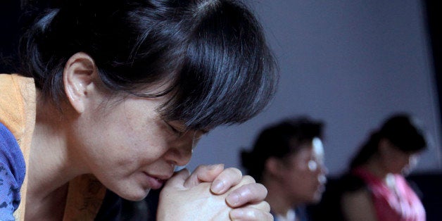 In this photo taken July 16, 2014, church members pray in a private room in Jiu'en Tang, a Christian church, in the Shuitou t