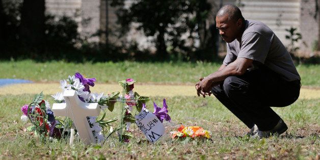 Terence Wright, of North Charleston, S.C., pays his respects at the scene where Walter Scott was killed by a North Charleston police officer Saturday, after a traffic stop in North Charleston, S.C., Thursday, April 9, 2015. Wright is a friend of the family. The officer, Michael Thomas Slager, has been fired and charged with murder. (AP Photo/Chuck Burton)