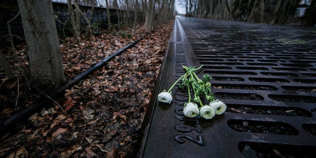 BERLIN, GERMANY - JANUARY 27: Roses left by mourners lie next to one of the many plaques detailing transports of Berlin Jews