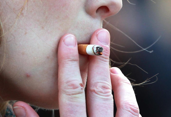 File photo dated 21/02/14 of a woman smoking, as a study suggested that smokers are around 70\% more likely to suffer from de
