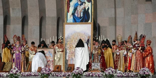 Armenian Church priests bless the icon with in Echmiadzin, the religious center of the Armenian Church outside the capital Yerevan, Armenia, Thursday, April 23, 2015. The Armenian Apostolic Church, the country's dominant religion, held services Thursday to canonize all victims. On Friday, April 24, Armenians will mark the centenary of what historians estimate to be the slaughter of up to 1.5 million Armenians by Ottoman Turks, an event widely viewed by scholars as genocide. Turkey, however, denies the deaths constituted genocide and says the death toll has been inflated. (AP Photo/Sergei Grits)