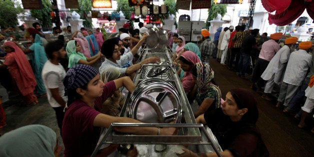 Volunteers wash used utensils inside the community kitchen at the Golden Temple, Sikh's holiest shrine, in Amritsar, India, Friday, June 3, 2011. The institution of the langar, or free community kitchen associated to a Sikh temple, was started by the first Sikh Guru. Food is served through the day in the kitchen of the Golden Temple to people regardless of religion and is maintained mainly by volunteers. (AP Photo/Altaf Qadri)