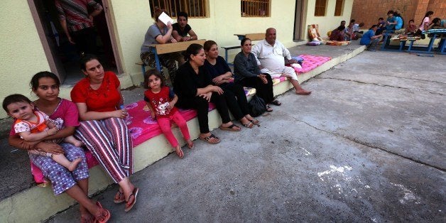 Iraqi Christian families fleeing the violence in the village of Qaraqush, about 30 kms east of the northern province of Nineveh, are pictured upon their arrival at a community center in the Kurdish city of Arbil in Iraq's autonomous Kurdistan region on June 28, 2014. AFP PHOTO/SAFIN HAMED (Photo credit should read SAFIN HAMED/AFP/Getty Images)