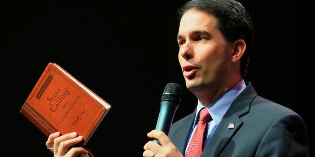 Wisconsin Gov. Scott Walker holds up a devotional while speaks at the Iowa Faith & Freedom 15th Annual Spring Kick Off, in Waukee, Iowa, Saturday, April 25, 2015. (AP Photo/Nati Harnik)