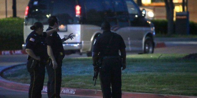 Police officers stands guard at a parking lot near the Curtis Culwell Center where a provocative contest for cartoon depictions of the Prophet Muhammad was held Sunday, May 3, 2015, in Garland, Texas. The contest was put on lockdown Sunday night and attendees were being evacuated after authorities reported a shooting outside the building. (AP Photo/LM Otero)