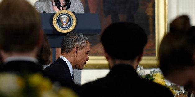 President Barack Obama bows his head in prayer as Pastor Amy Butler of Manhattan's Riverside Church gives the opening prayer during an Easter Prayer Breakfast at the White House in Washington, Tuesday, April 7, 2015. The president welcomed Christian leaders to the White House for a prayer breakfast Tuesday, taking a mild poke at some of his critics in his Easter-themed remarks. (AP Photo/Susan Walsh)