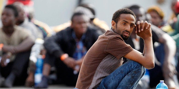 Migrants wait after disembarking from the Iceland Coast Guard vessel Tyr, at the Messina harbor, Sicily, southern Italy, Wedn