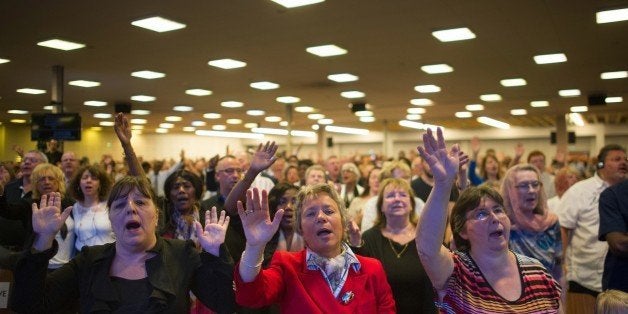 People raise their hands as they pray during Sunday worship at the newly renovated Evangelist church 'La porte ouverte' ('The open door') in Mulhouse on May 10, 2015. The renovated church, which claims to be the largest Evangelical church in France, was inaugurated on May 9, enlarged from 3,000 to 7,000 m2 to accommodate over 2,000 faithfuls each Sunday. AFP PHOTO / SEBASTIEN BOZON (Photo credit should read SEBASTIEN BOZON/AFP/Getty Images)