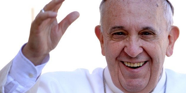 Pope Francis salutes the crowd as he arrives for his weekly general audience in St Peter's square at the Vatican on April 22,
