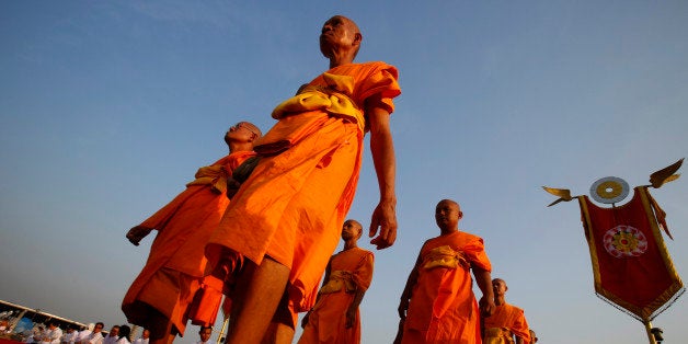 Thai Buddhist monks walk to the gates of the main temple of Wat Dhammakaya temple in Pathum Thani province to participate in