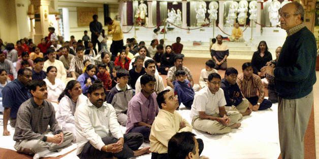 CHANTILLY, UNITED STATES: Shiva Pant (L), explains about the temple's efforts to raise money to the Indian community for the tsunami victims during a Hindu prayer service 30 December, 2004 at the Rajdhani Mandir temple in Chantilly, Virgina. The confirmed death toll in the massive earthquake and tidal waves that slammed Indian Ocean shorelines at the weekend climbed to more than 118,000 on 30 December. AFP PHOTO / TIM SLOAN (Photo credit should read TIM SLOAN/AFP/Getty Images)
