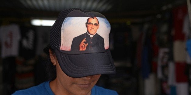 A vendor wears a cap with the portrait of Salvadorean Monsignor Oscar Romero (1917-1980) in San Salvador on May 19, 2015. Mon