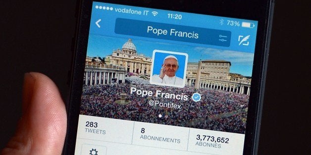 A mobile phone displays a tweet of Pope Francis reading 'Please pray for me' on his @Pontifex twitter account on March 13, 20