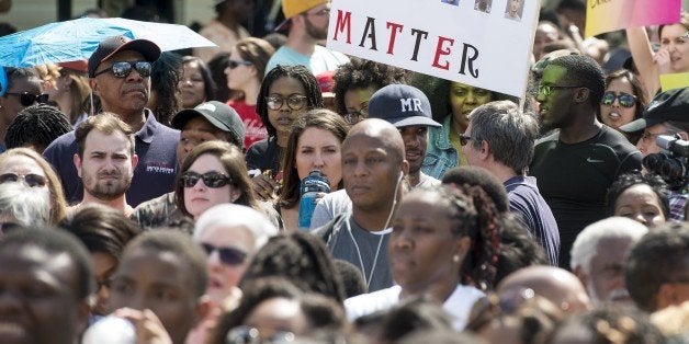 People gather for a rally in front of City Hall in Baltimore, Maryland, on May 3, 2015 calling for peace following widespread riots. The riots stemmed from protests over the death of Freddie Gray, 25, who suffered a serious spinal injury while in the back of a police van on April 12. AFP PHOTO/NICHOLAS KAMM (Photo credit should read NICHOLAS KAMM/AFP/Getty Images)