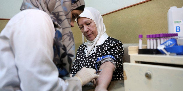In this Sunday, June 14, 2015, photo, a nurse takes blood from a patient at Jordan's National Center for Diabetes in Amman, J