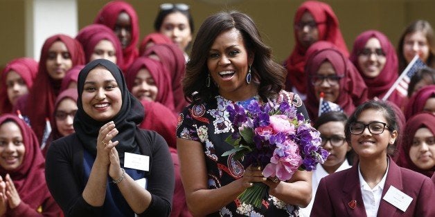 US First Lady Michelle Obama (C) reacts as she watches an interpretive dance performance during a welcome for her arrival at Mulberry School for Girls during a visit as part of the US government's 'Let Girls Learn' initiative in east London on June 16, 2015. On the first full day of a visit to Britain the US First Lady met with local students in east London and discussed how Britain and the US are working together in order to attempt to expand access to adolescent girls' education around the world. While in London, the First Lady will also host a roundtable meeting on Let Girls Learn, and meet with British Prime Minister Cameron, Samatha Cameron, and Prince Harry. AFP PHOTO / JUSTIN TALLIS (Photo credit should read JUSTIN TALLIS/AFP/Getty Images)