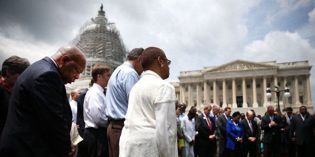 WASHINGTON, DC - JUNE 18: Rep. John Lewis (D-GA) (L) joins members of the US House of Representatives and members of the US Senate in a prayer circle in front of the US Capitol to honor those gunned down last night inside the historic Emanuel African Methodist Episcopal Church in Charleston South Carolina, June 18, 2015 in Washington, DC. Police have arrested Dylann Roof, 21, of Lexington, South Carolina in the shooting that killed 9 people. (Photo by Mark Wilson/Getty Images)