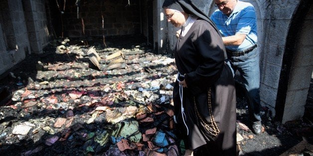 A nun inspects the damage at a room located on the complex of the Church of the Multiplication at Tabgha, on the shores on th