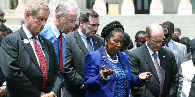 WASHINGTON, DC - JUNE 18: Rep. Sheila Jackson Lee (D-TX) (C) prays alongside Rep. Joe Wilson (R-SC) (L), Sen. Chuck Grassley (R-IA) (2nd L), Sen. Chris Coons (D-DE) (R) and other members of the US House of Representatives and US Senate in front of the US Capitol to honor those gunned down last night inside the historic Emanuel African Methodist Episcopal Church in Charleston South Carolina, June 18, 2015 in Washington, DC. Police have arrested Dylann Roof, 21, of Lexington, South Carolina in the shooting that killed 9 people. (Photo by Mark Wilson/Getty Images)