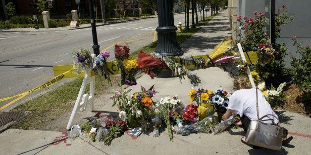 A woman places flowers at a makeshift memorial near the Emanuel AME Church June 18, 2015 in Charleston, South Carolina, after a mass shooting at the Church on the evening of June 17, 2015. US police on Thursday arrested a 21-year-old white gunman suspected of killing nine people at a prayer meeting in one of the nation's oldest black churches in Charleston, an attack being probed as a hate crime. The shooting at the Emanuel African Methodist Episcopal Church in the southeastern US city was one of the worst attacks on a place of worship in the country in recent years, and comes at a time of lingering racial tensions. AFP PHOTO/BRENDAN SMIALOWSKI (Photo credit should read BRENDAN SMIALOWSKI/AFP/Getty Images)