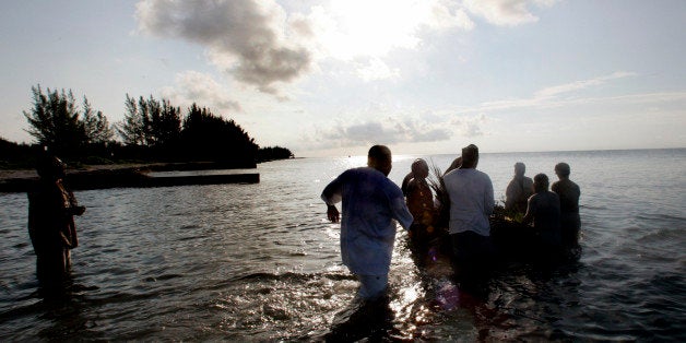 A group of men wade into the ocean as they push a small raft loaded with offerings to their ancestors out to sea Sunday, June 19, 2005 on Virginia Key, Miami's former "black only" beach. The ceremony is part of the Juneteenth celebration, an unofficial black holiday that marks the day on June 19, 1865 when slaves in Texas learned that Abraham Lincoln had signed the Emancipation Proclamation two years earlier. (AP Photo/Wilfredo Lee)