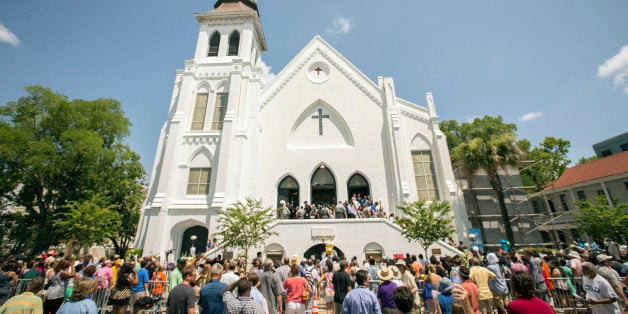 People stand outside as parishioners leave the Emanuel A.M.E. Church, Sunday, June 21, 2015, in Charleston, S.C., four days after a mass shooting at the church claimed the lives of its pastor and eight others. (AP Photo/Stephen B. Morton)