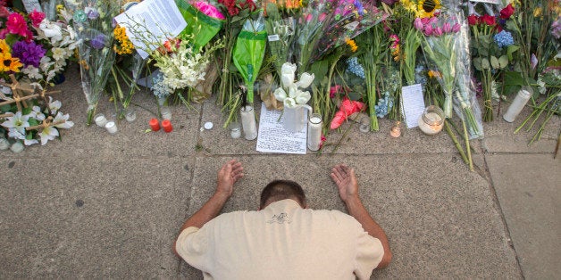 Raymond Smith of Charleston kneels in prayer at the front of the Emanuel AME Church before Sunday, June 21, 2015, before the first worship service since nine people were fatally shot at the church during a Bible study group, in Charleston, S.C. (AP Photo/Stephen B. Morton)