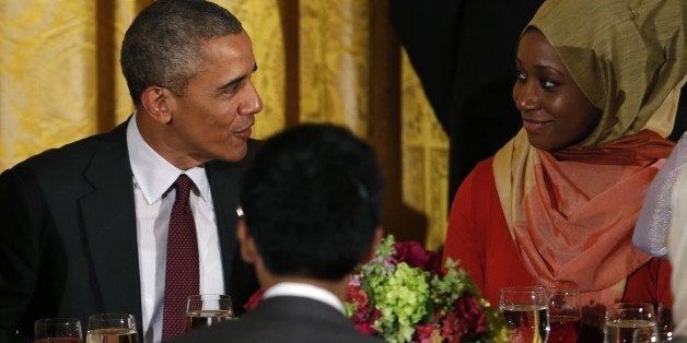 US President Barack Obama talks to a guest during an Iftar dinner celebrating Ramadan in the State Dining Room at the White H