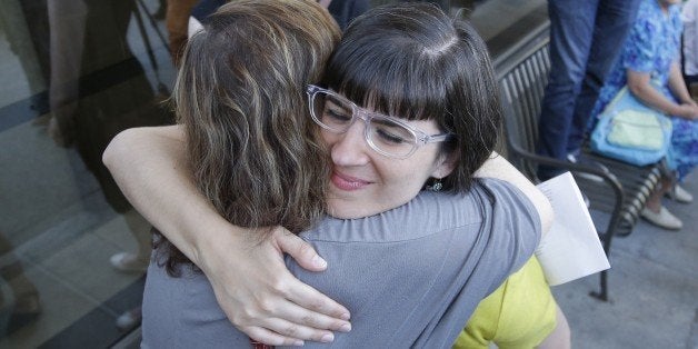 Kate Kelly receives a hug from a supporter after walking to the Church Office Building of the Church of Jesus Christ of Latter-day Saints Sunday, June 22, 2014, in Salt Lake City. While Kelly's former church leaders meet in Virginia on Sunday night to decide if she'll be ousted from her church, the founder of a prominent Mormon women's group will hold a vigil in Salt Lake City along with hundreds of her supporters. The leader of Ordain Women is accused of apostasy, defined as repeated and public advocacy of positions that oppose church teachings. (AP Photo/Rick Bowmer)